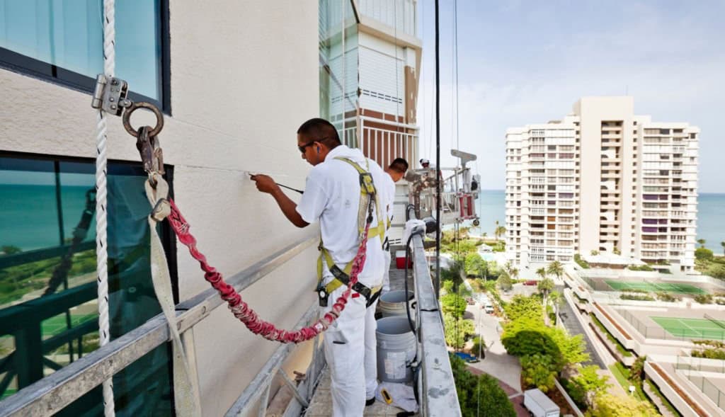 Professional painters applying commercial paint in a warehouse