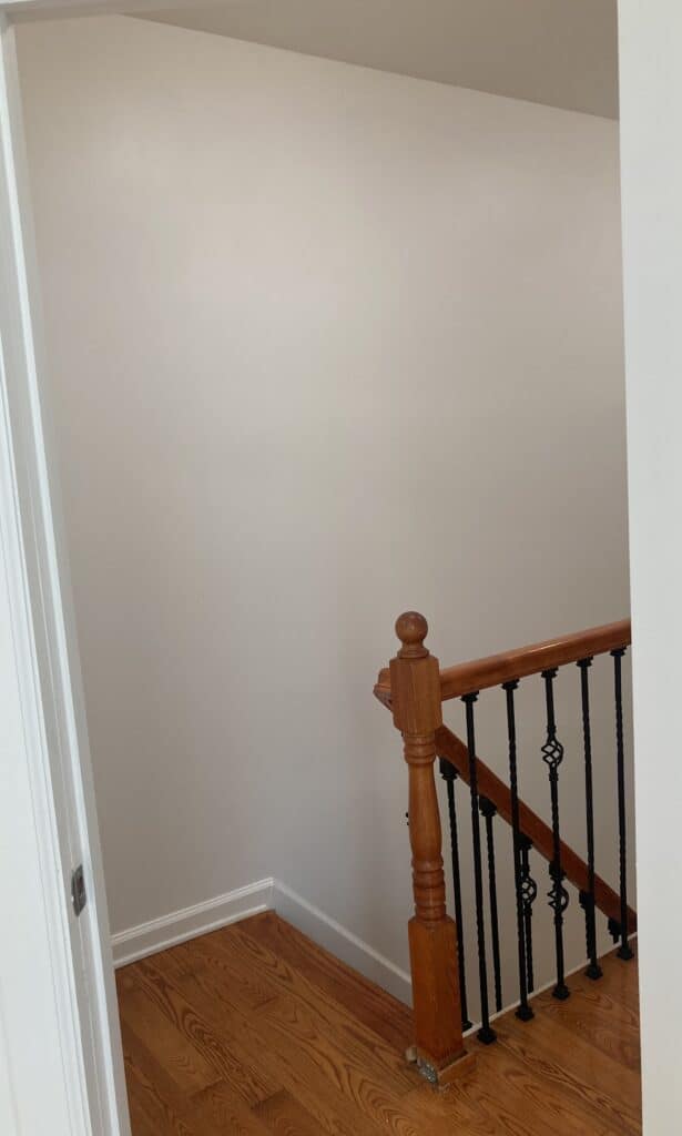 Interior staircase with wooden railing and freshly painted walls, showcasing a clean and modern aesthetic suitable for commercial and residential properties.