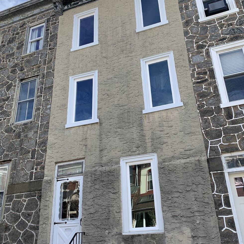 Facade of a commercial building in New Castle County, Delaware, featuring freshly painted beige stucco walls and white-framed windows, highlighting quality craftsmanship and aesthetic appeal in commercial painting services.